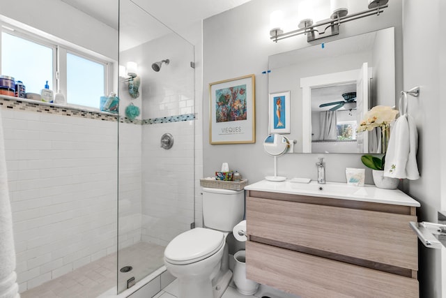 bathroom with vanity, a tile shower, and toilet