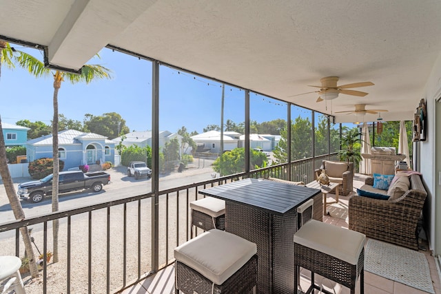 sunroom / solarium featuring ceiling fan