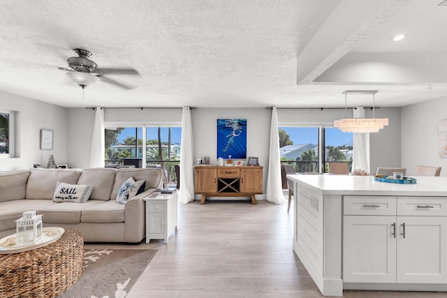 living room with a healthy amount of sunlight, a textured ceiling, and light hardwood / wood-style floors