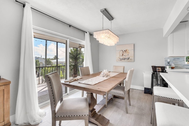 dining area featuring light hardwood / wood-style floors and a notable chandelier