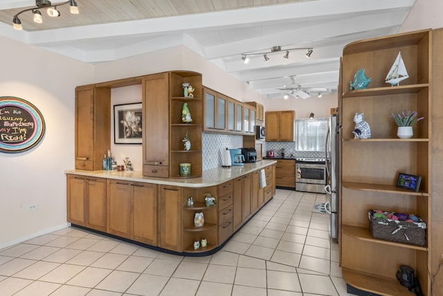 kitchen featuring light tile patterned flooring, stainless steel appliances, decorative backsplash, and beamed ceiling