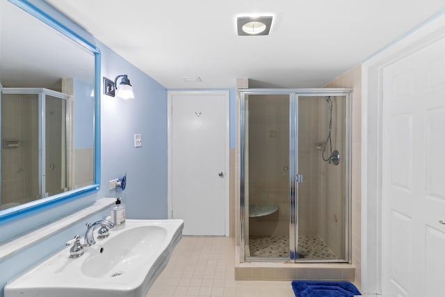 bathroom featuring an enclosed shower, sink, and tile patterned flooring