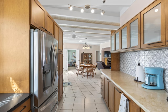 kitchen with pendant lighting, tasteful backsplash, light tile patterned floors, stainless steel refrigerator with ice dispenser, and beam ceiling