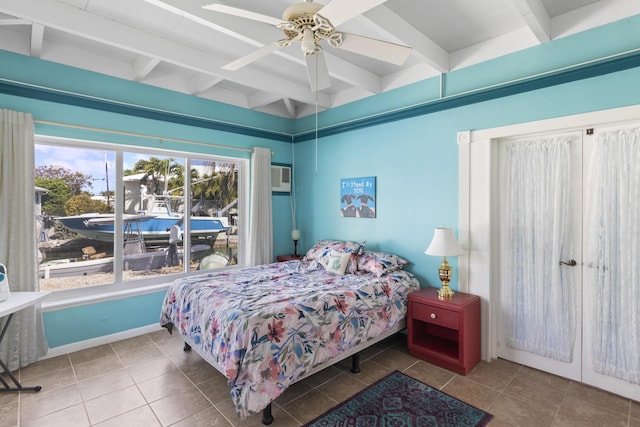 bedroom with ceiling fan, a wall unit AC, and beam ceiling