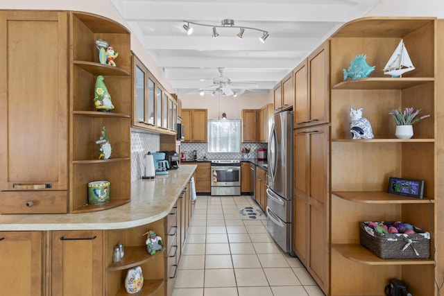 kitchen with vaulted ceiling with beams, light tile patterned floors, appliances with stainless steel finishes, ceiling fan, and decorative backsplash