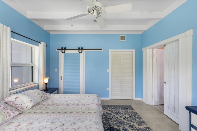 tiled bedroom featuring multiple closets, ceiling fan, and beam ceiling