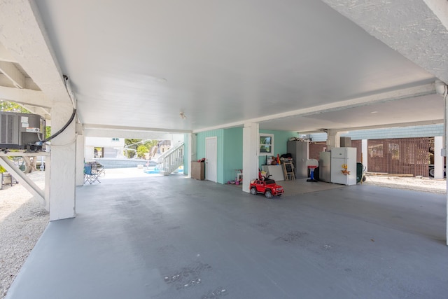 garage featuring central air condition unit and white fridge