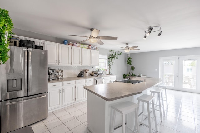 kitchen with appliances with stainless steel finishes, a center island, and white cabinets