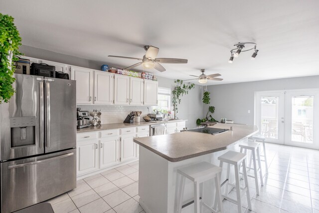 kitchen with appliances with stainless steel finishes, a center island, and white cabinets