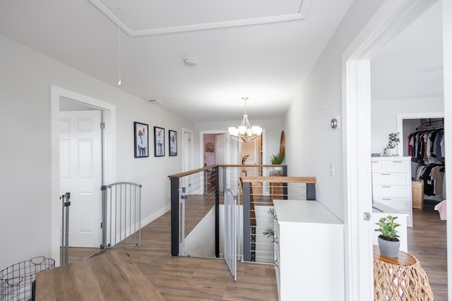 hall with dark hardwood / wood-style floors and a notable chandelier