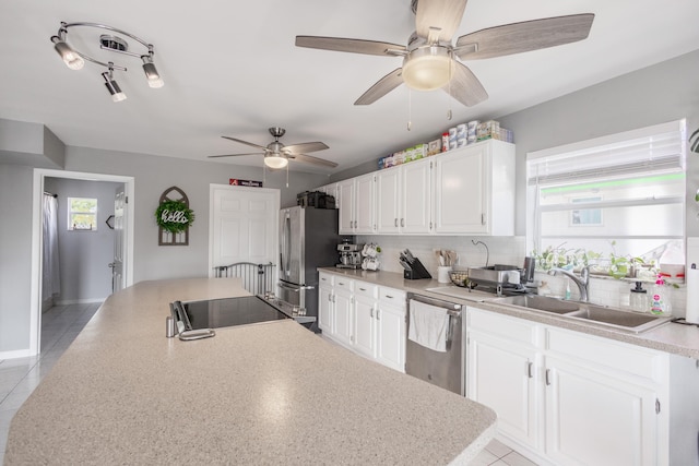 kitchen with sink, decorative backsplash, stainless steel appliances, and white cabinets