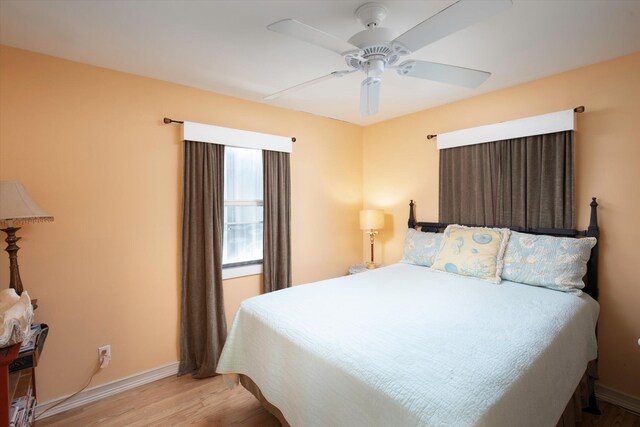 bedroom featuring a ceiling fan, baseboards, and wood finished floors