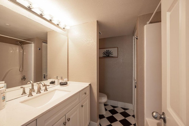 bathroom with vanity, baseboards, a shower, tile patterned floors, and toilet