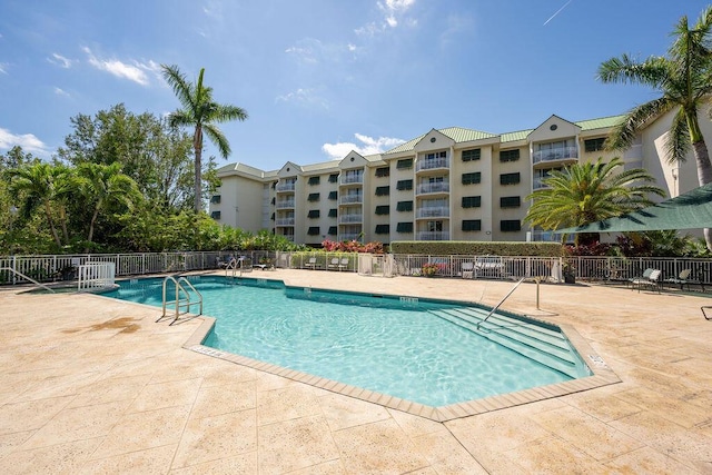 pool with a patio area and fence