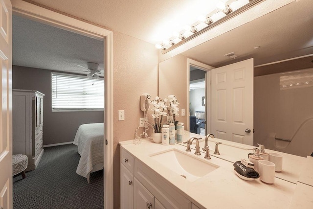 full bath featuring vanity, a ceiling fan, baseboards, ensuite bathroom, and a textured ceiling