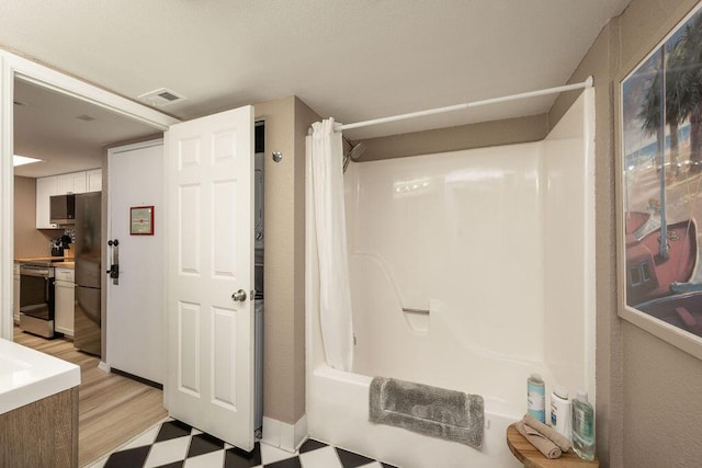 bathroom with visible vents, shower / tub combo, and baseboards