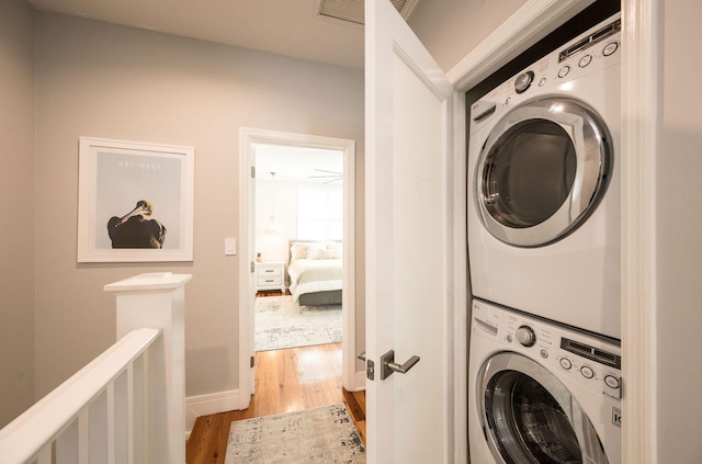 106 Admirals Ln, Key West, FL 33040 - clothes washing area with stacked washer and clothes dryer, light wood finished floors, and baseboards