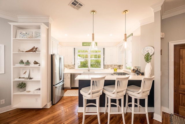 106 Admirals Ln, Key West, FL 33040 - kitchen with stainless steel appliances, a peninsula, a sink, light countertops, and wood finished floors