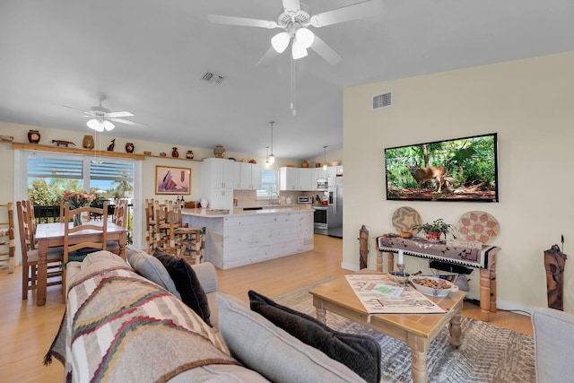 31135 Hollerich Dr, Big Pine, FL 33043 - living room with ceiling fan, light wood finished floors, plenty of natural light, and vaulted ceiling