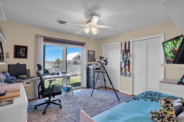 31135 Hollerich Dr, Big Pine, FL 33043 - bedroom with multiple closets, a desk, access to exterior, wood finished floors, and a ceiling fan