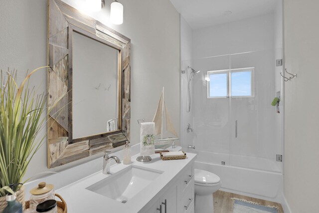 full bathroom featuring vanity, hardwood / wood-style flooring, shower / bathtub combination, and toilet