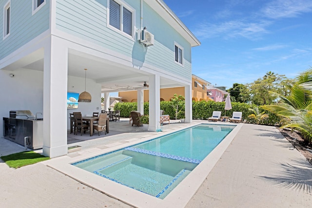 view of pool with a patio area, an in ground hot tub, and exterior kitchen