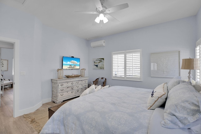 bedroom with ceiling fan, light hardwood / wood-style floors, and an AC wall unit