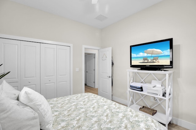 bedroom featuring ceiling fan, light wood-type flooring, and a closet