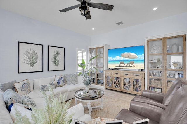 living room with ceiling fan and light wood-type flooring