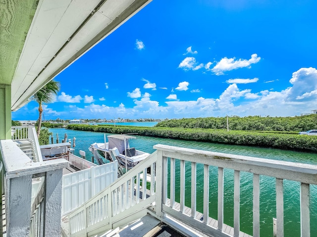 balcony with a water view and a boat dock