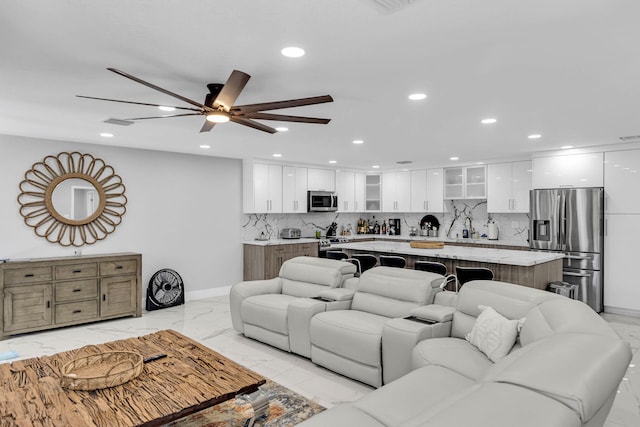 living area with baseboards, marble finish floor, a ceiling fan, and recessed lighting