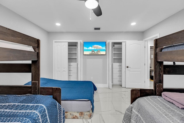 bedroom featuring marble finish floor, two closets, recessed lighting, ceiling fan, and baseboards