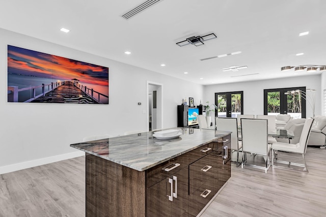 kitchen with visible vents, modern cabinets, dark brown cabinets, french doors, and light wood-style floors