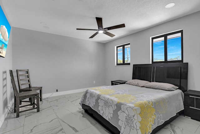 bedroom featuring a textured ceiling, marble finish floor, a ceiling fan, and baseboards