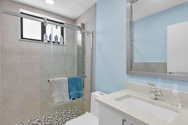 bathroom with a stall shower, vanity, and toilet