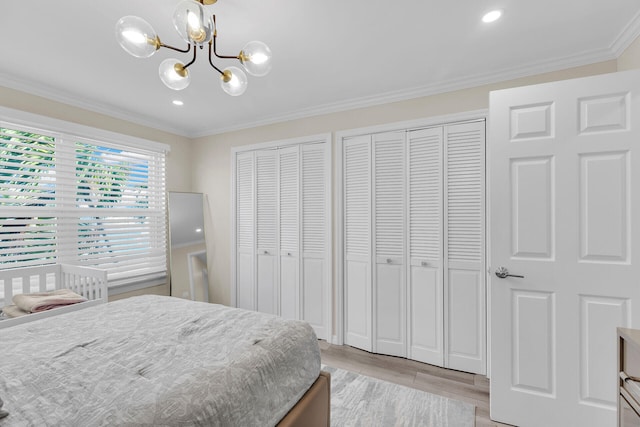 3314 Northside Dr Unit 53, Key West, FL 33040 - bedroom featuring an inviting chandelier, light wood finished floors, multiple closets, and crown molding