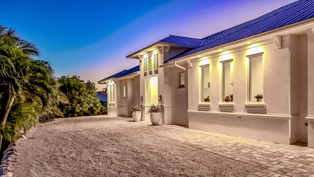 property exterior at dusk with a patio area