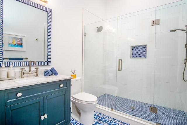 bathroom featuring vanity, a shower with shower door, and toilet