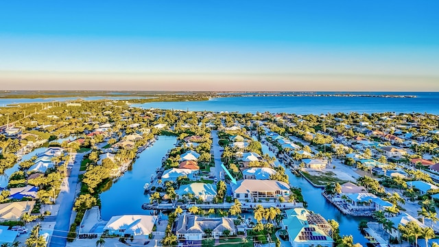 aerial view at dusk featuring a water view