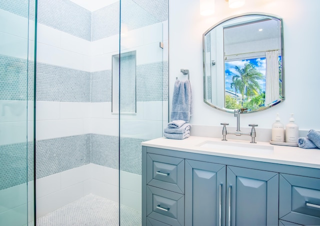 bathroom with tiled shower and vanity