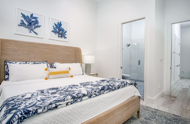 bedroom featuring ensuite bath and wood-type flooring