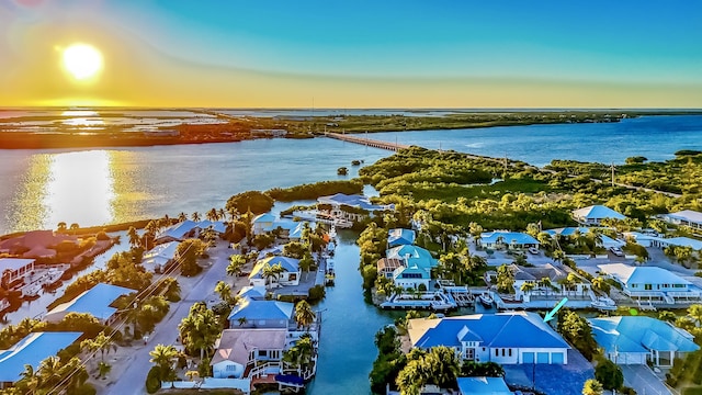 aerial view at dusk featuring a water view