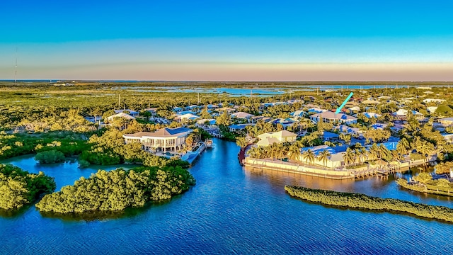 aerial view at dusk featuring a water view