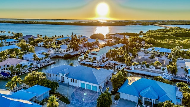 aerial view at dusk featuring a water view