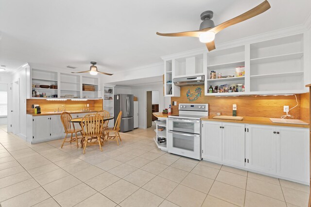 kitchen with range with two ovens, white cabinetry, ornamental molding, and stainless steel fridge