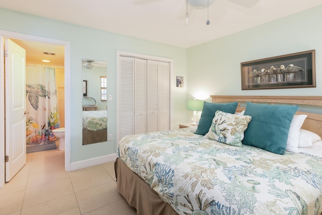 tiled bedroom featuring ensuite bathroom, ceiling fan, and a closet