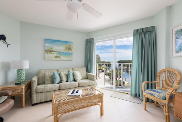 tiled living room with ceiling fan and a water view