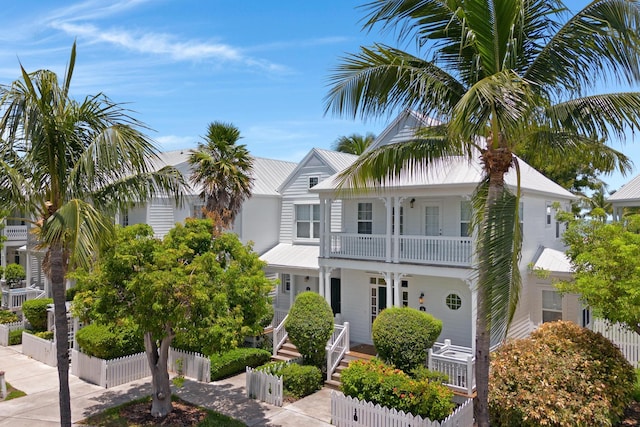 view of front of property with a porch, a fenced front yard, and a balcony