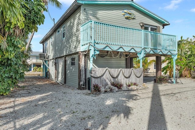 view of side of home featuring cooling unit and a balcony