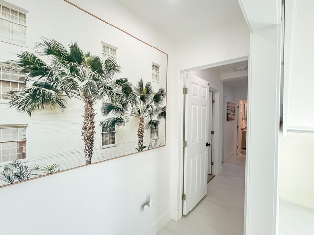 hall featuring baseboards and light wood-style floors